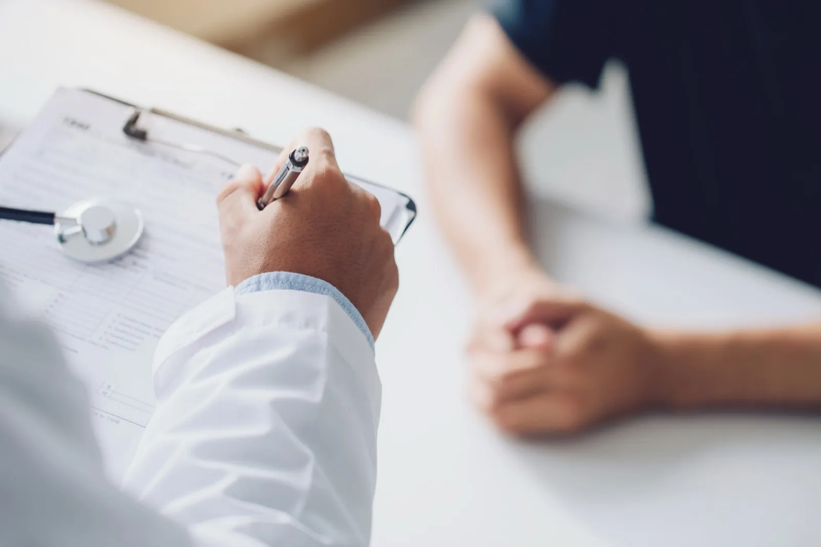 A clinician taking notes on a clipboard