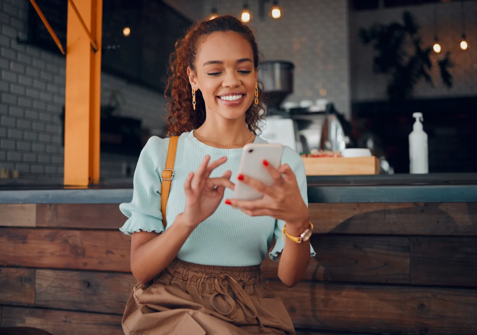 A woman smiling as she messages on her phone
