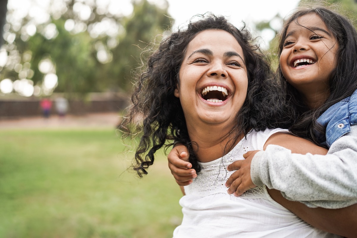 Mother and child laughing outdoors